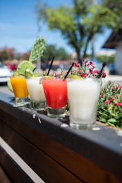 three clear drinking glasses with orange and white liquid