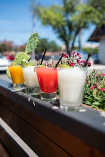 three clear drinking glasses with orange and white liquid