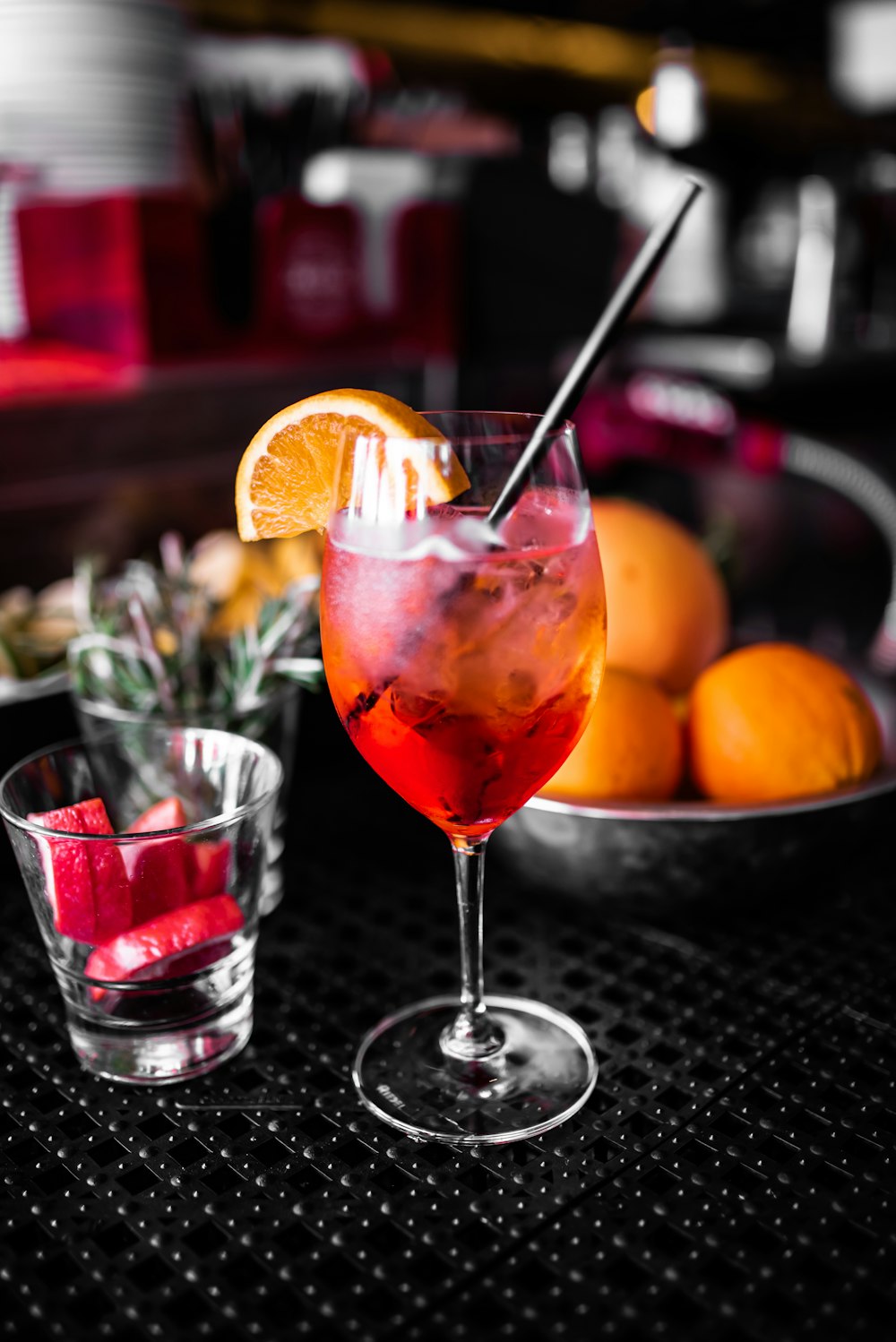 clear drinking glass with red liquid and sliced orange fruit