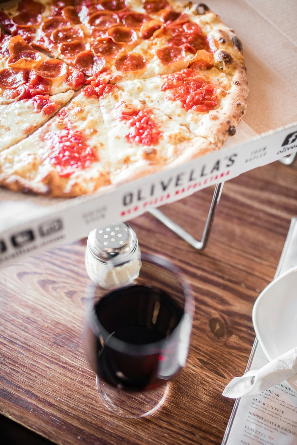 pizza on white ceramic plate beside clear drinking glass