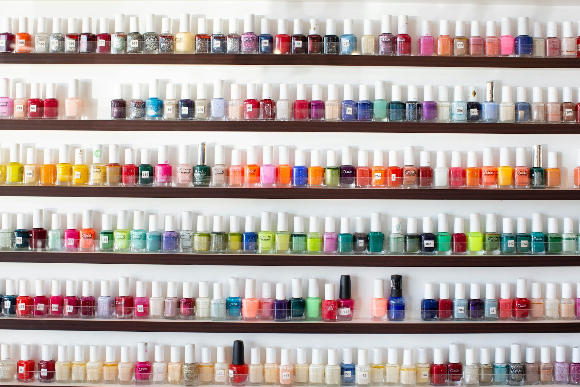 white and pink plastic bottles on white shelf