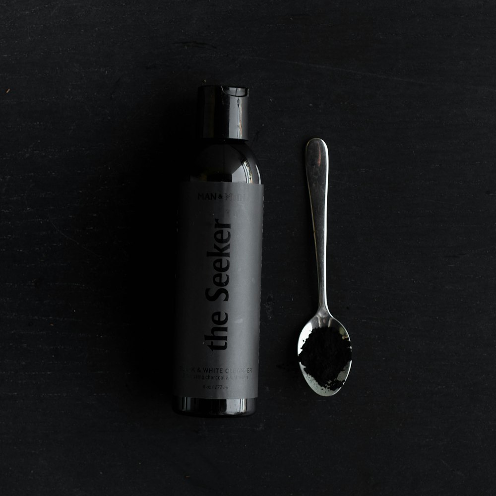 stainless steel spoon beside gray bottle