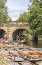 people riding on boat on river under bridge during daytime