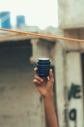 Close-up of a sleek UrbanLens camera resting on a concrete ledge with blurred city lights in the background.
