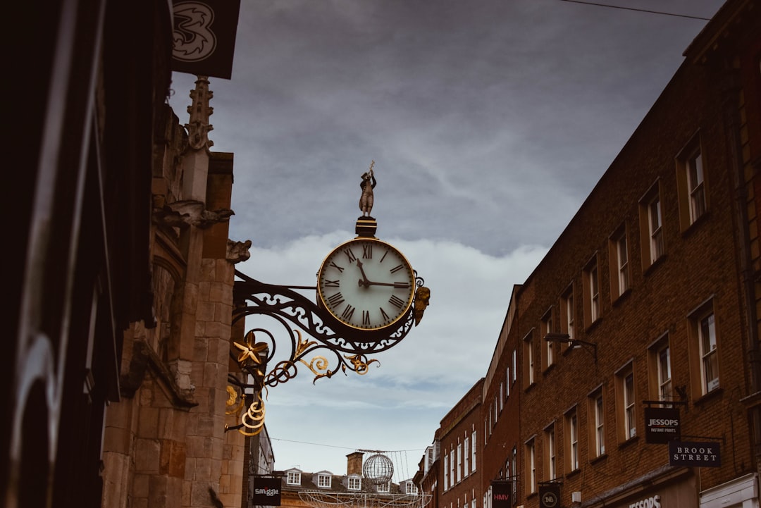 brown concrete building with analog clock,