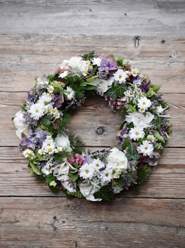 A cheerful spring wreath featuring blooming flowers and greenery.