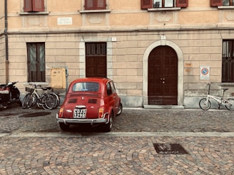 red volkswagen beetle parked beside black bicycle during daytime