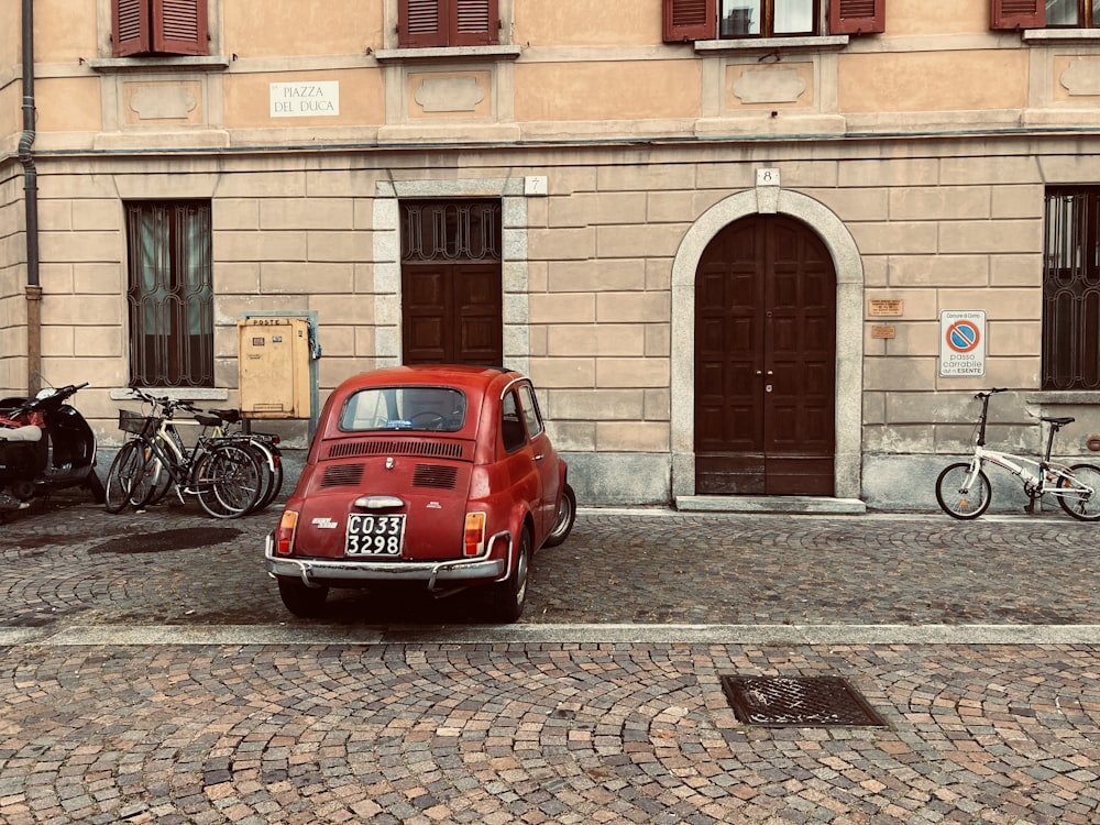red volkswagen beetle parked beside black bicycle during daytime
