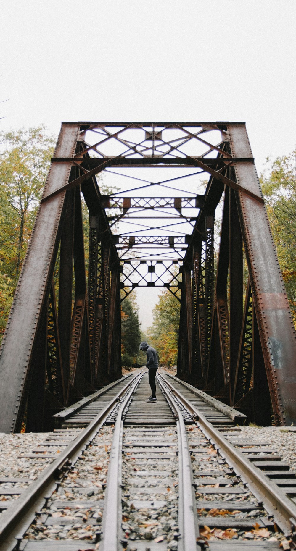 person walking on brown wooden bridge during daytime