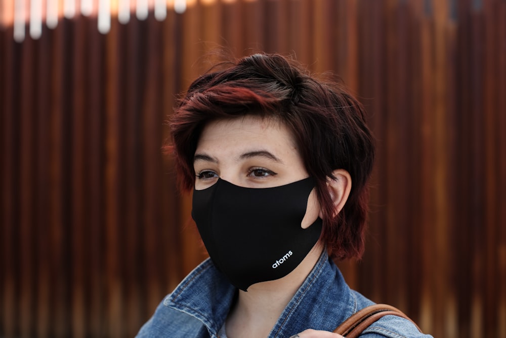 woman in blue denim jacket wearing black mask
