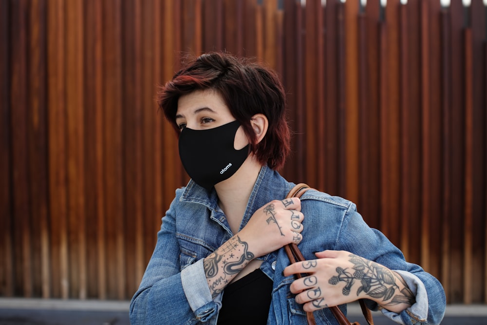 woman in blue denim jacket wearing black mask