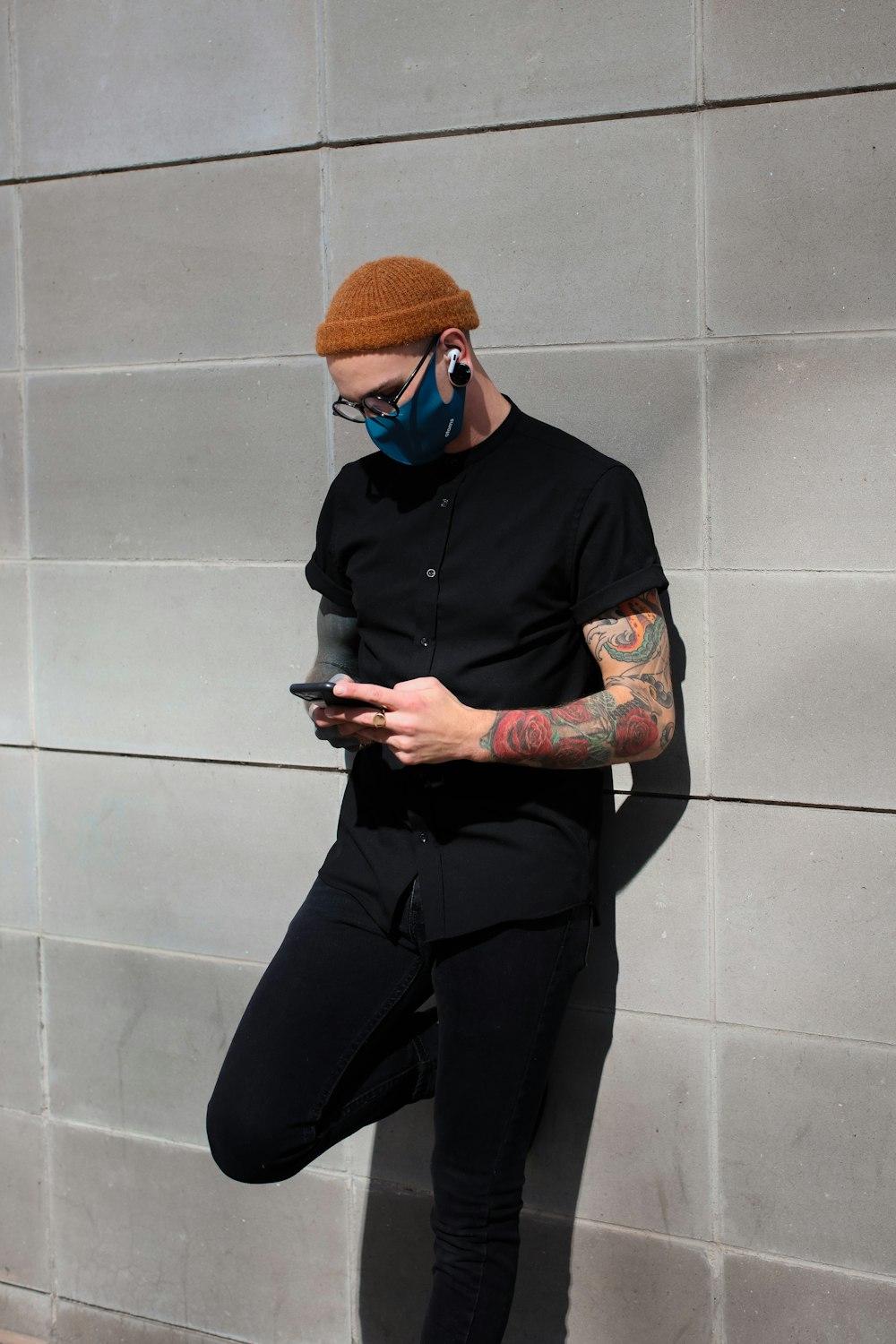 man in black jacket and pants holding smartphone