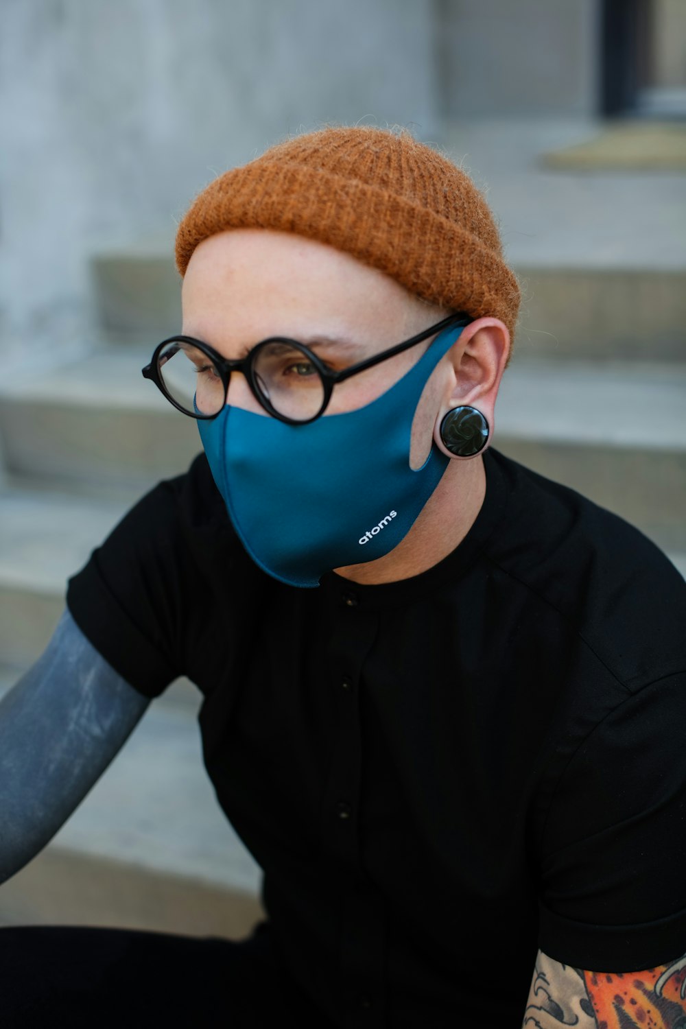 man in black button up shirt wearing brown knit cap and blue goggles