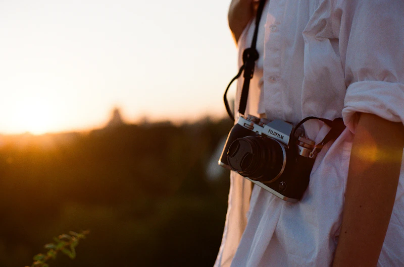 Person holding a black DSLR camera