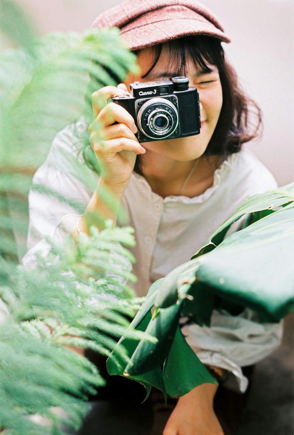 woman in white shirt holding black and silver camera