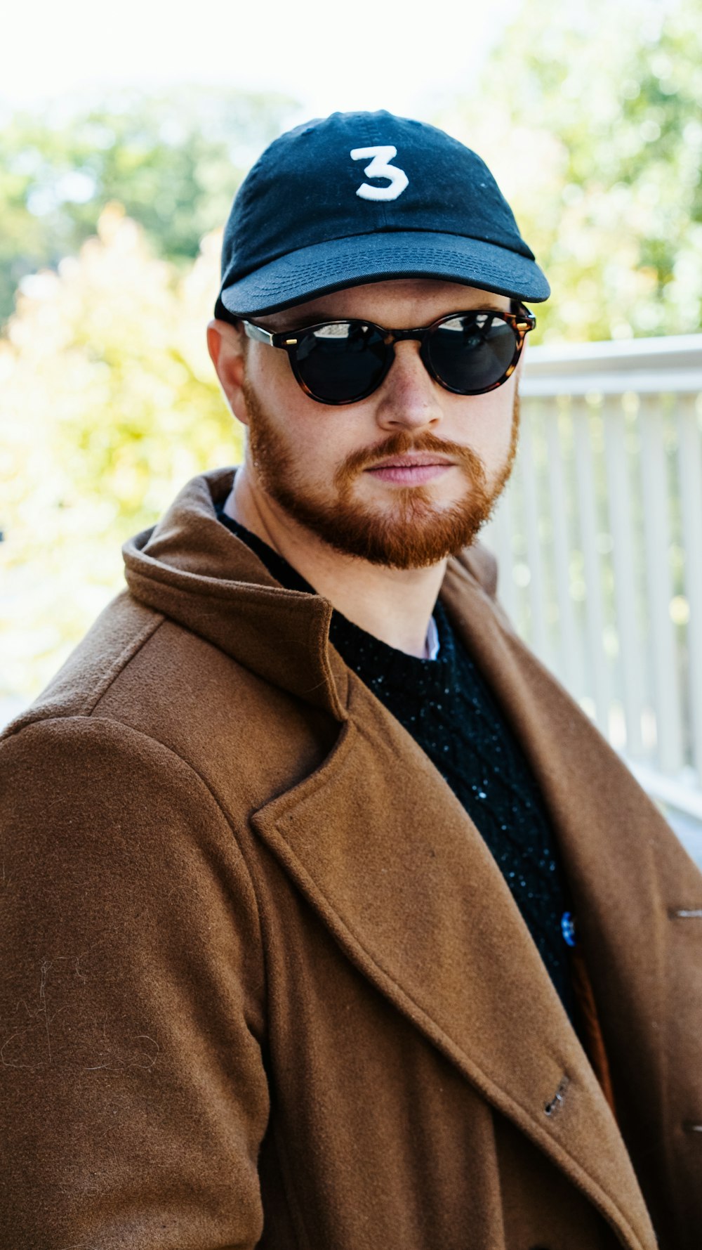 man in brown coat wearing black sunglasses