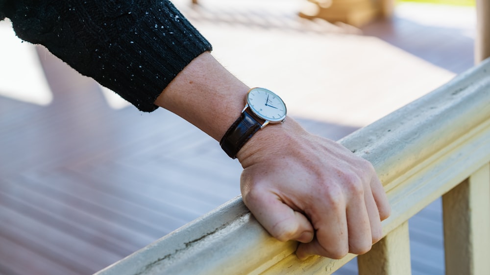 person wearing silver round analog watch