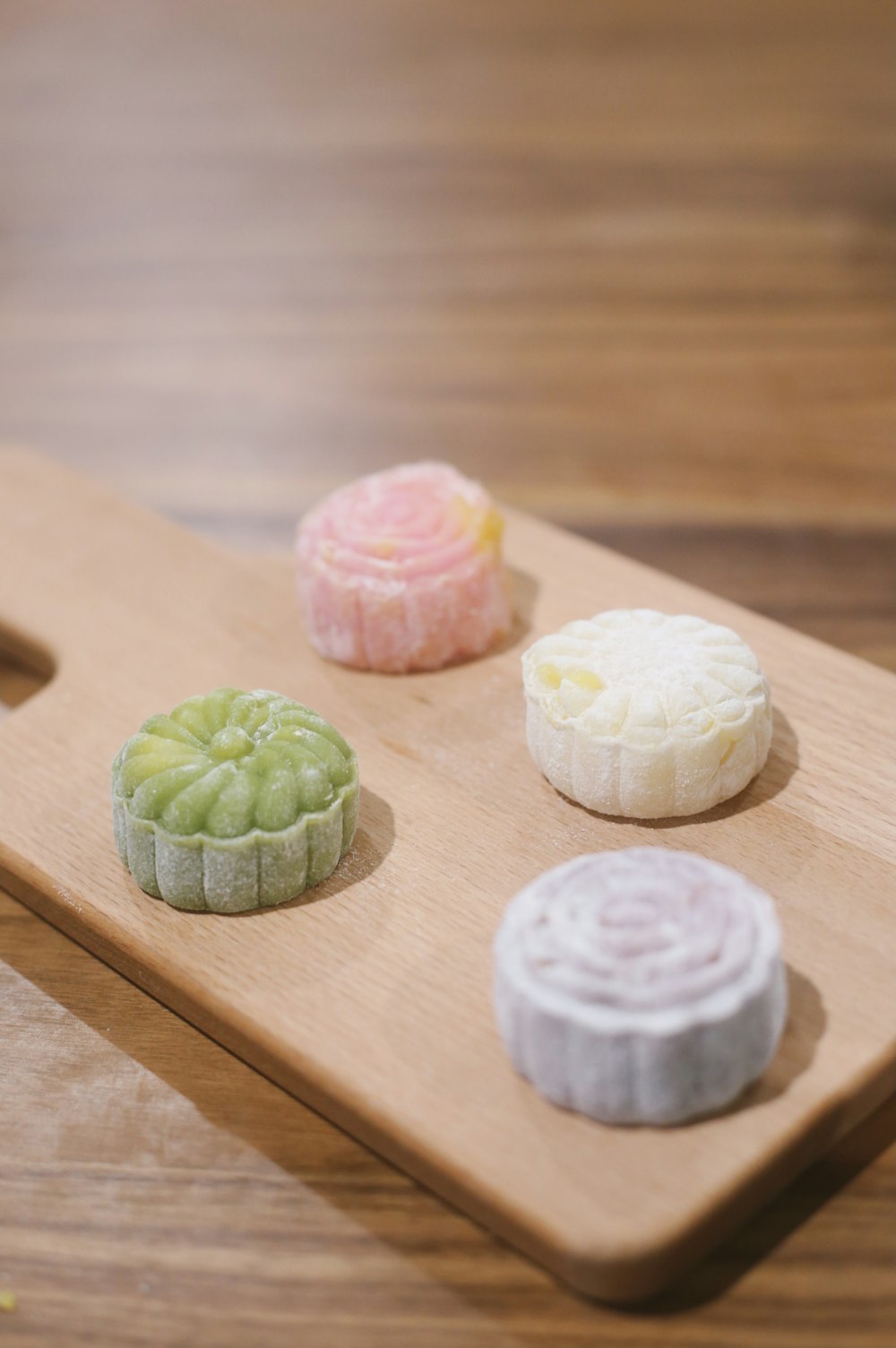 white and pink round cookies on brown wooden chopping board