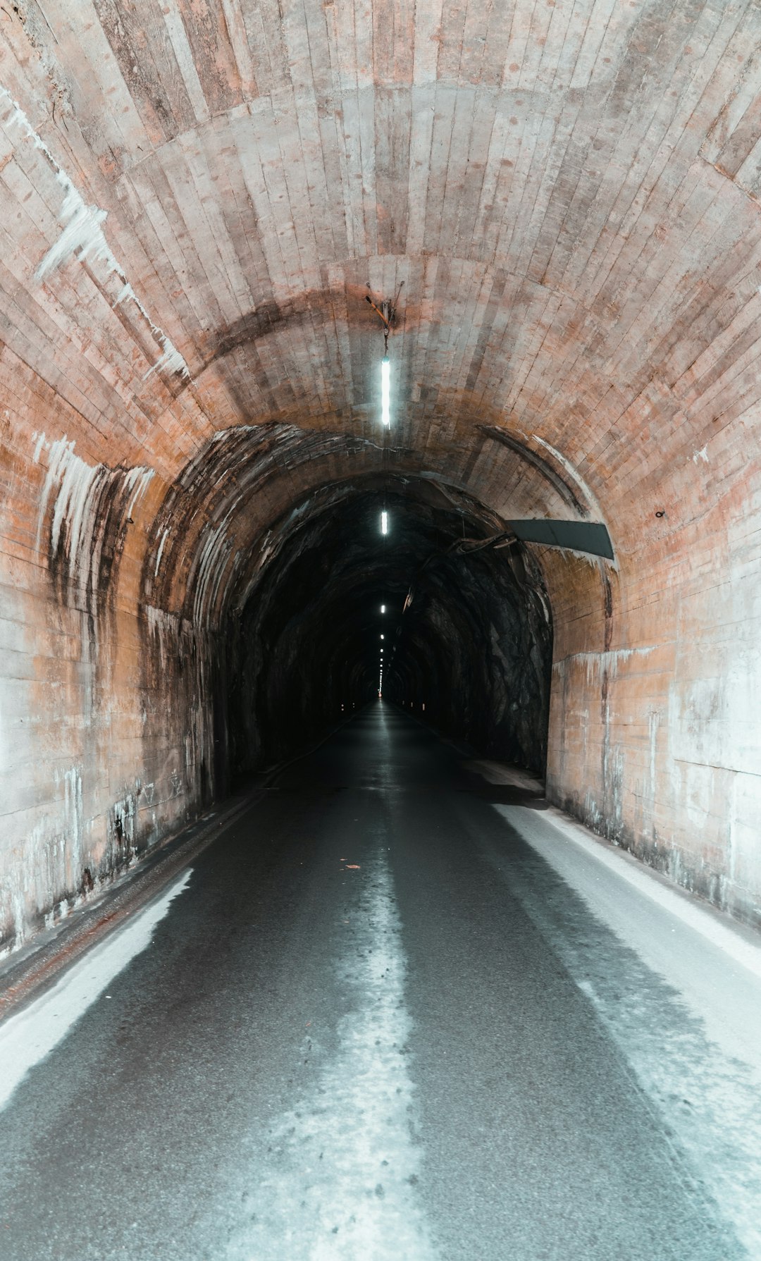 empty tunnel with light turned on during daytime