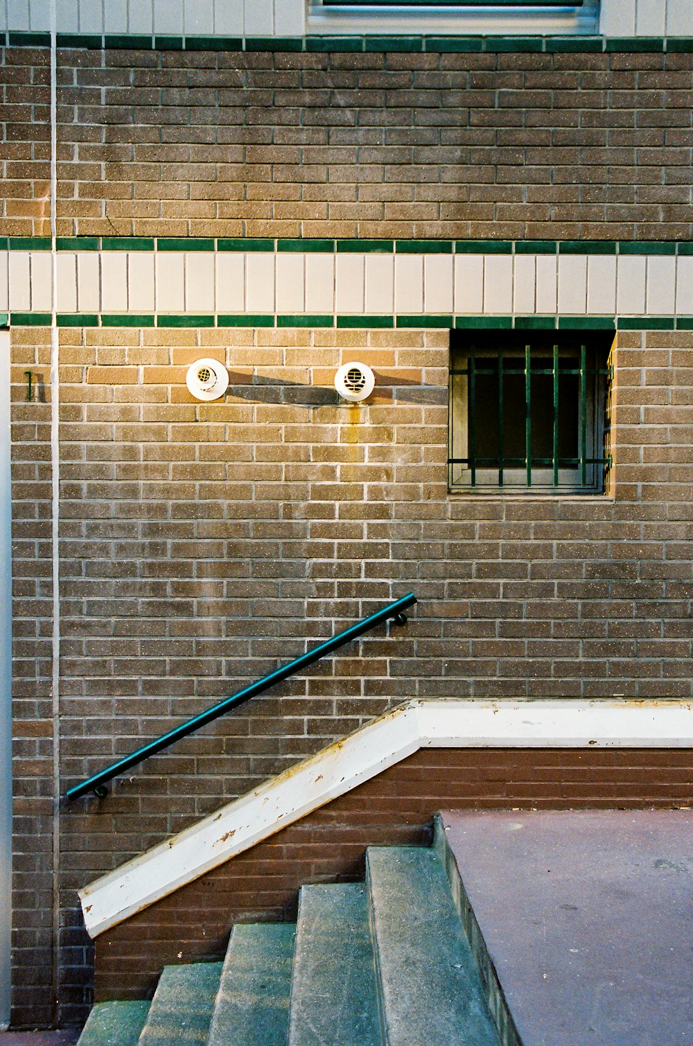 blue metal railings on brown brick wall