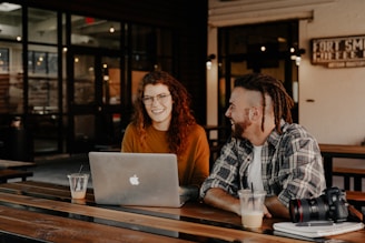 A friendly small business owner chatting with a web designer over coffee.