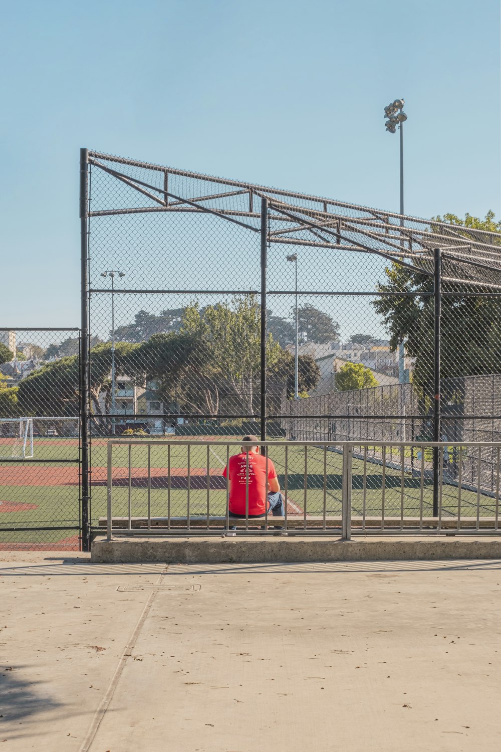 person in red hoodie sitting on brown wooden bench