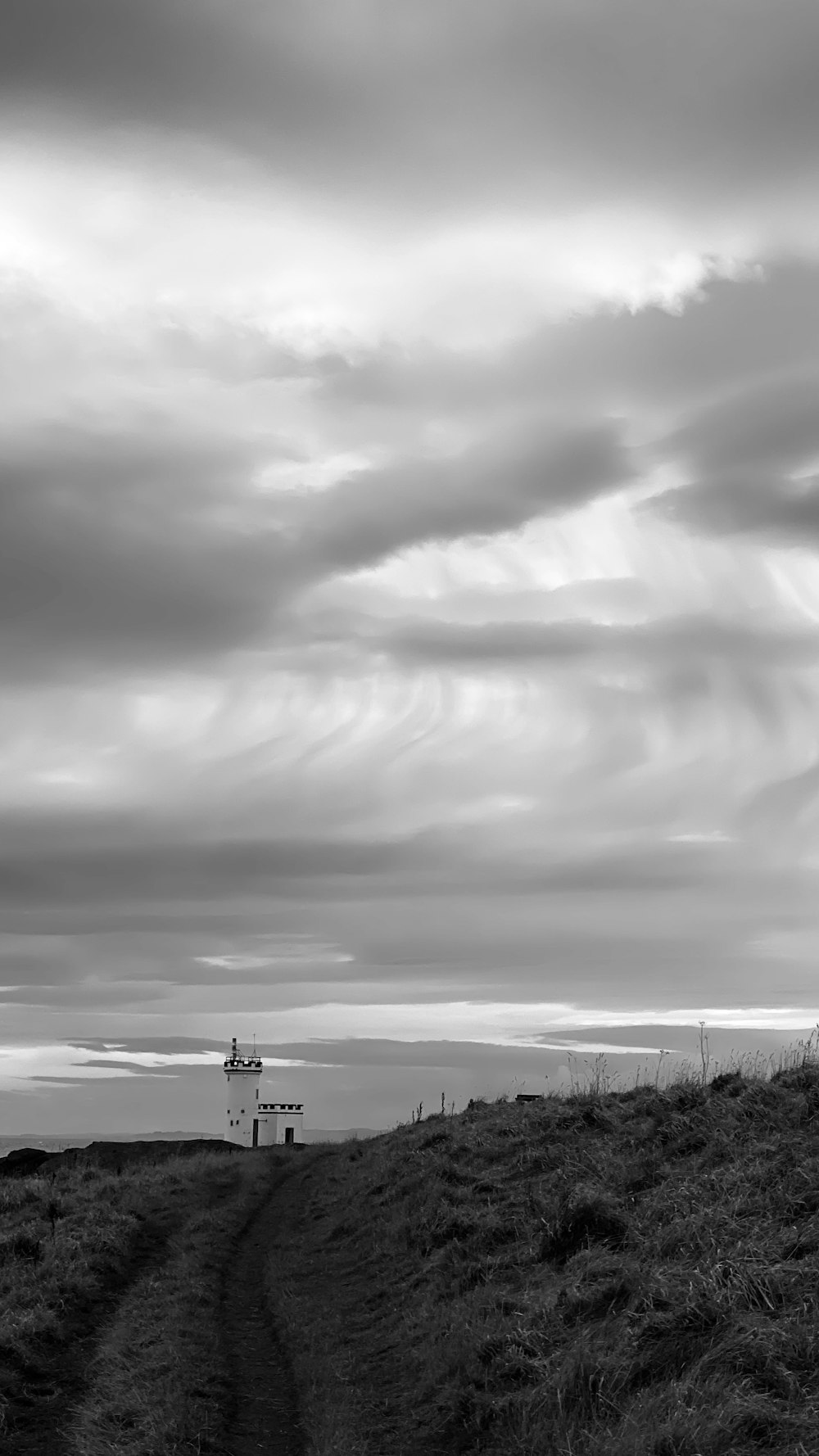 grayscale photo of a factory under cloudy sky