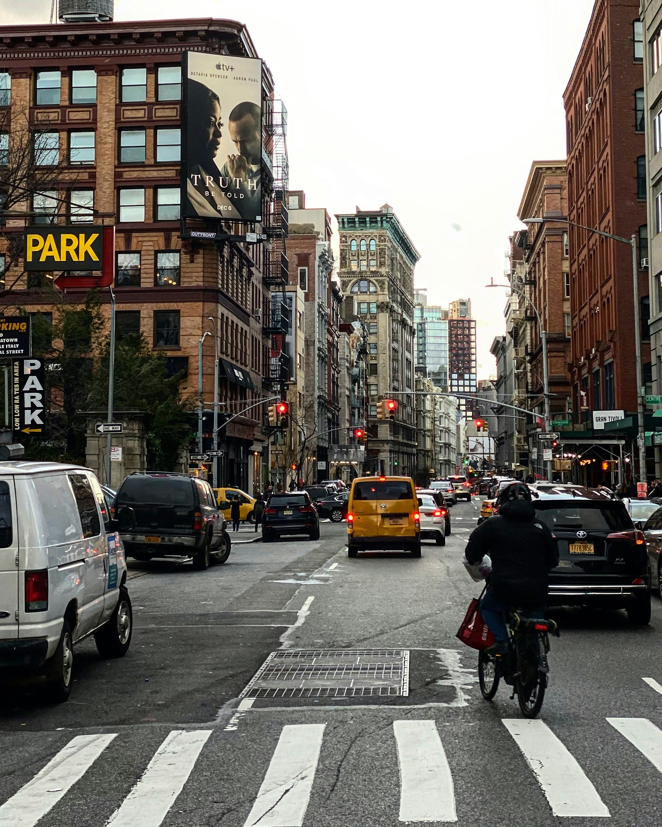 Stylish person in Manhattan street with dramatic city architecture, cool blue-gray urban tones, overcast sky