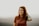 woman in brown crew neck t-shirt holding blue plastic bottle