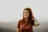 woman in brown crew neck t-shirt holding blue plastic bottle