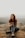 woman in brown long sleeve shirt and blue denim jeans sitting on rock