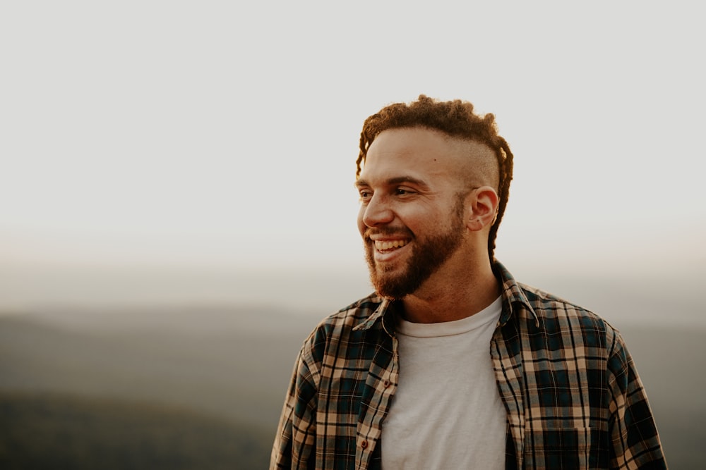 um homem com dreadlocks sorri para a câmera