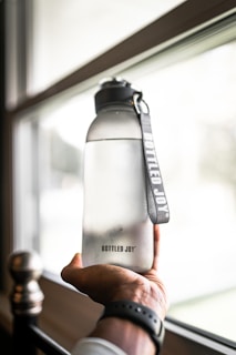 person holding gray and black tumbler