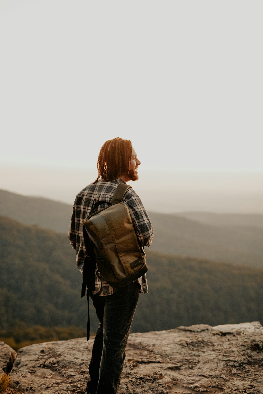 woman in black and white plaid long sleeve shirt carrying brown backpack