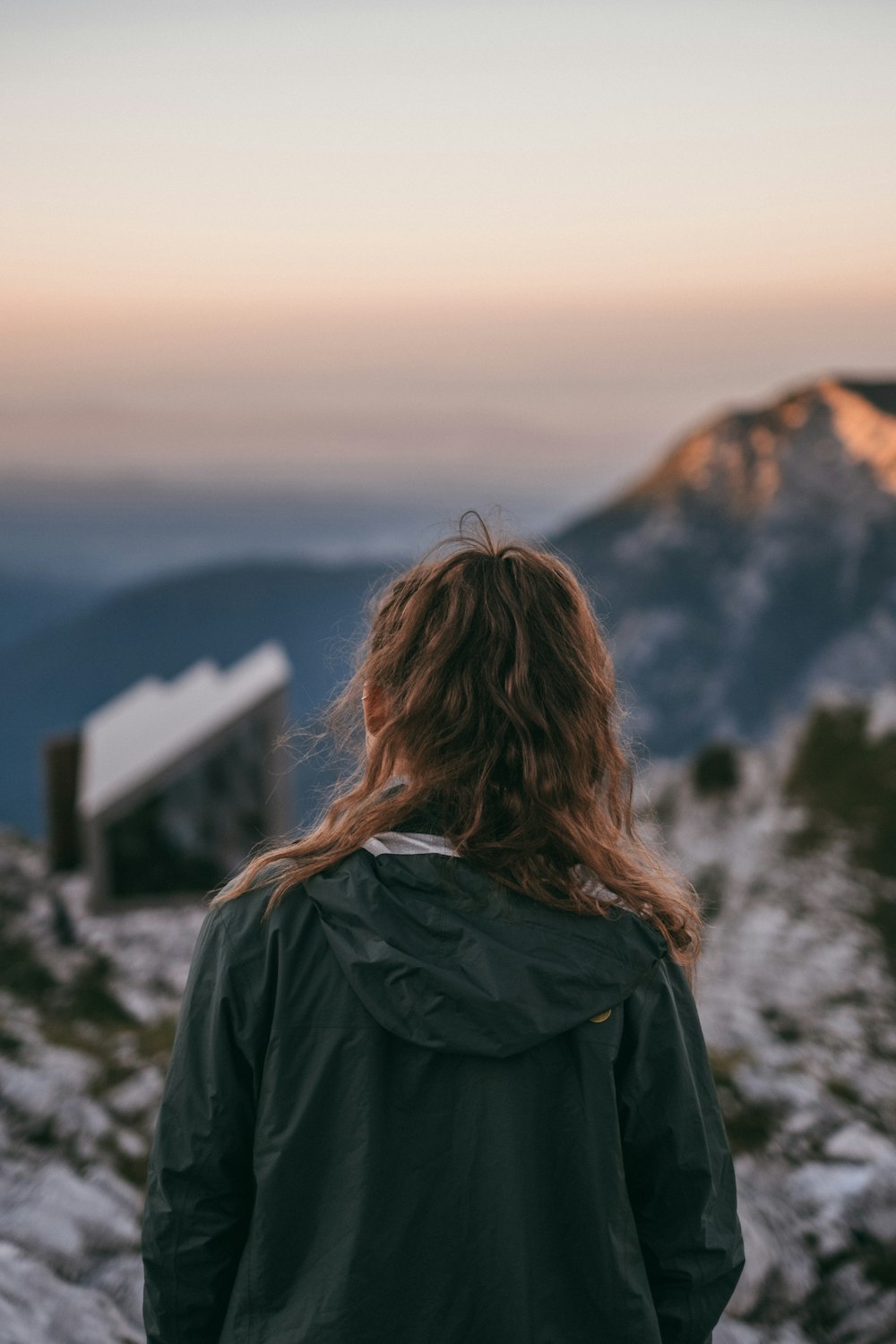 woman in black jacket standing on mountain during daytime