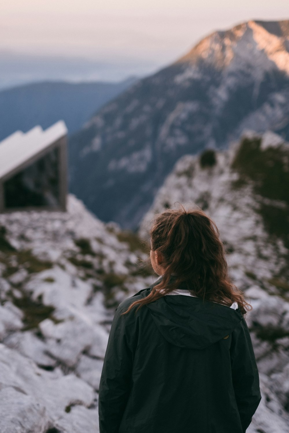 woman in black jacket standing on snow covered ground during daytime