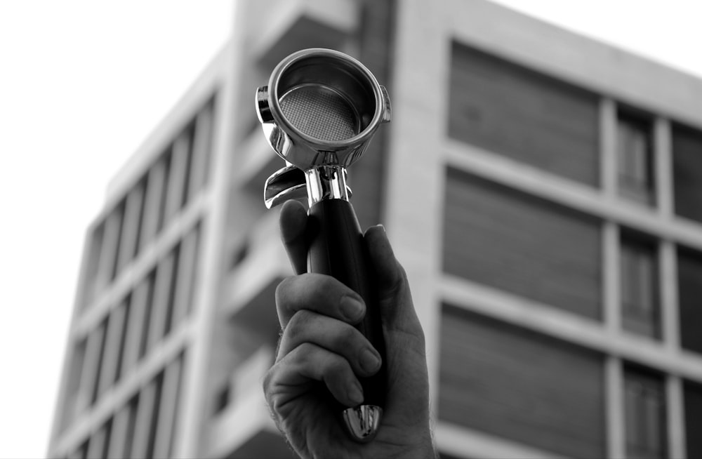 person holding magnifying glass in grayscale