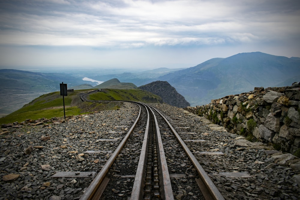 train rail near mountains during daytime