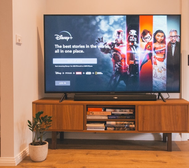 black flat screen tv turned on on brown wooden tv rack