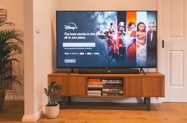 black flat screen tv turned on on brown wooden tv rack