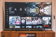 black flat screen tv turned on displaying man in black suit