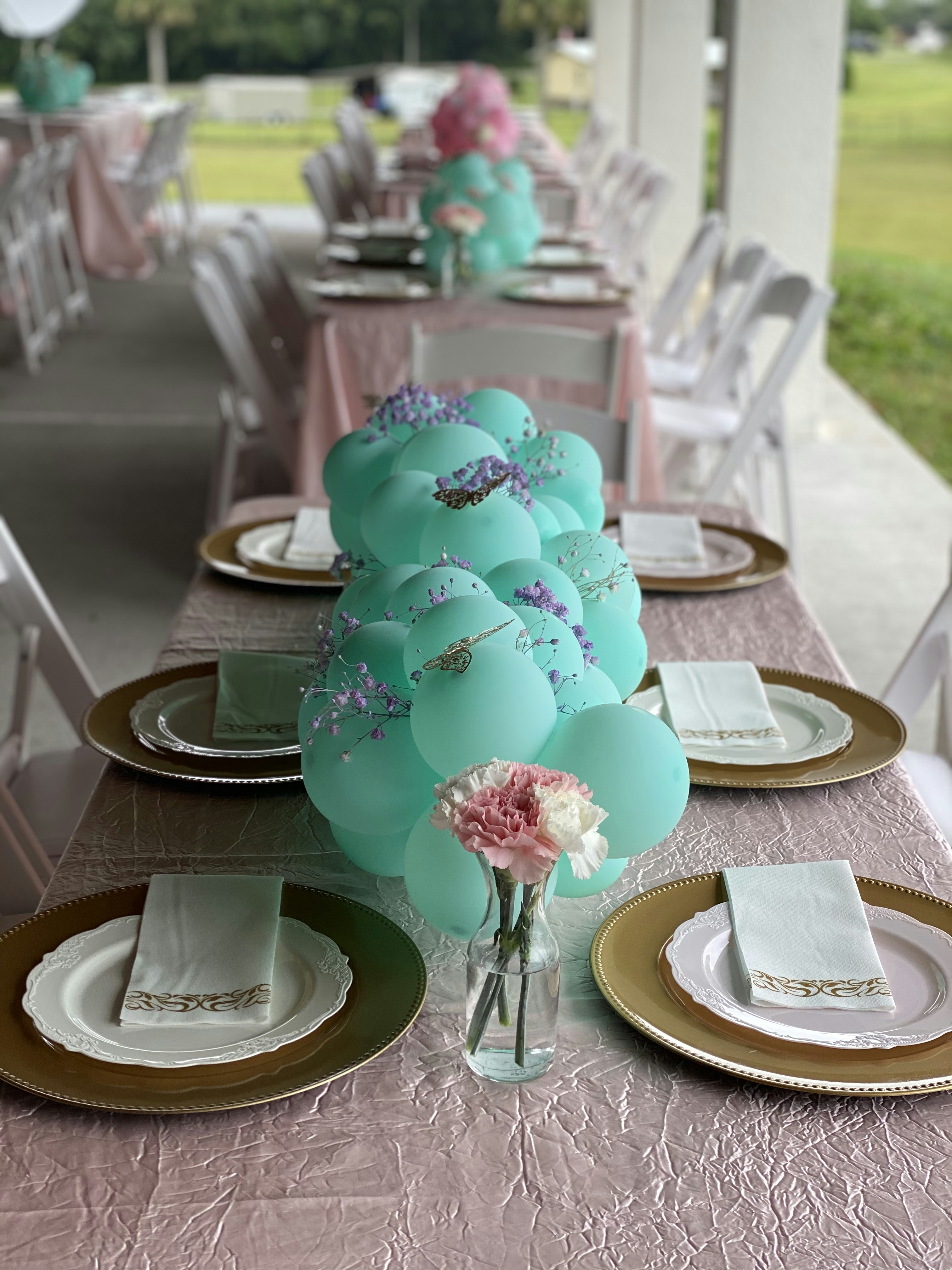 Pink Barbie themed party table with pink balloons and glitter decorations in bright light