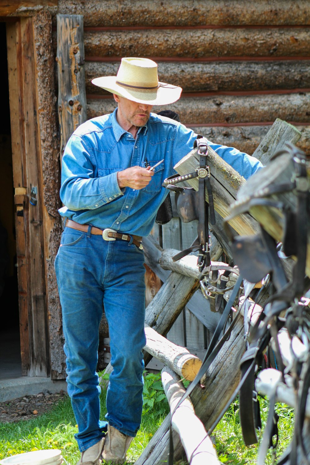 man in blue denim jacket and brown cowboy hat standing beside bicycle during daytime