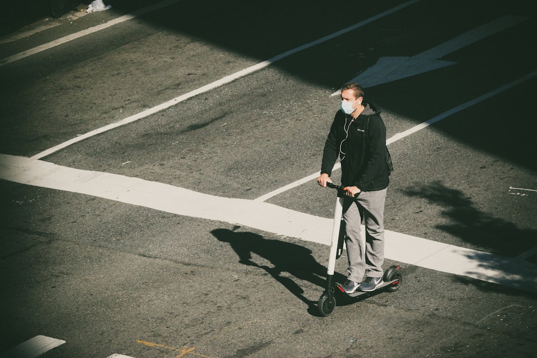 man in black jacket and gray pants standing on gray asphalt road during night time