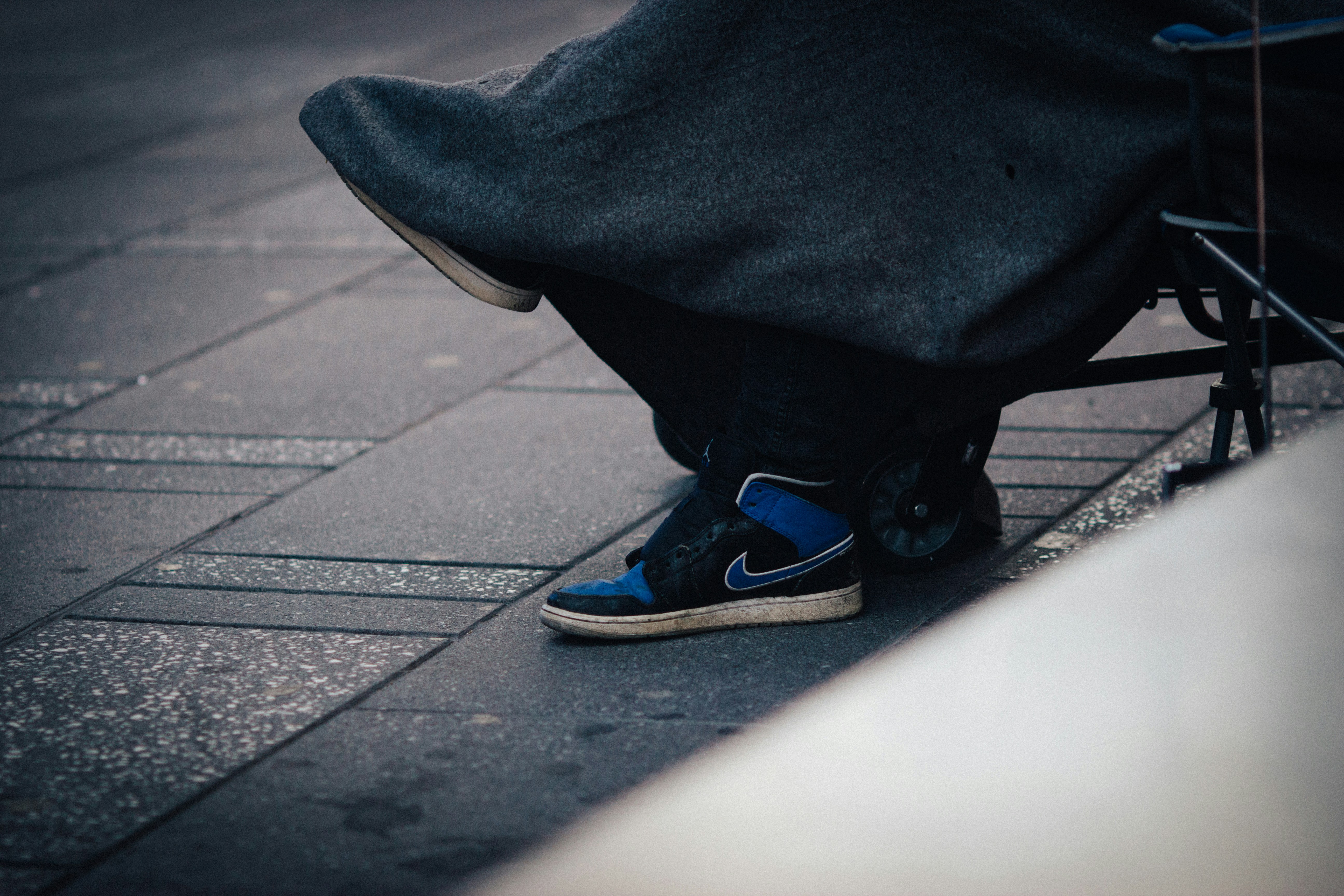 person in black pants and blue and white nike sneakers