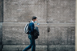 A person confidently using a safety app on their phone while walking in a busy city street.