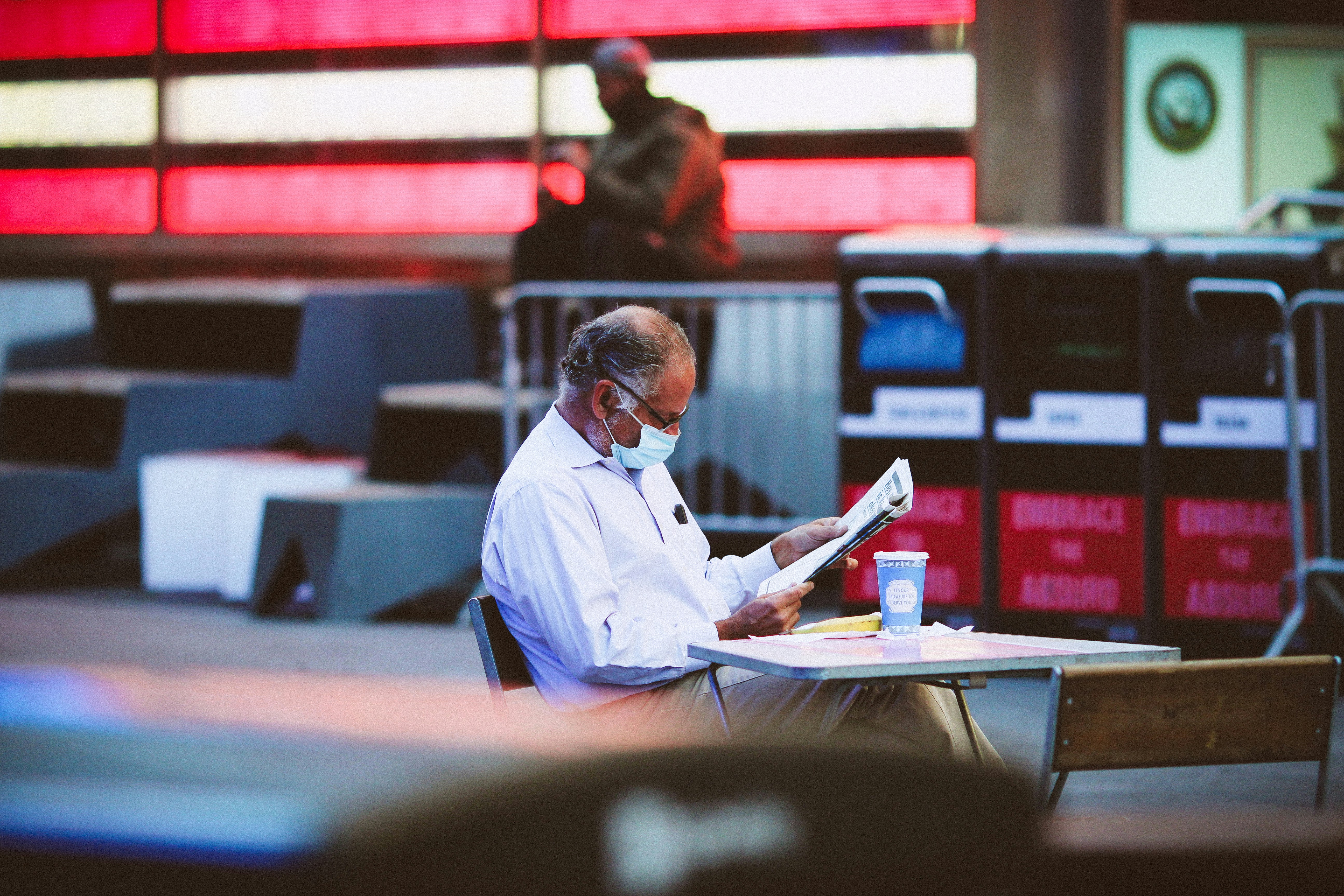 man in blue dress shirt reading book