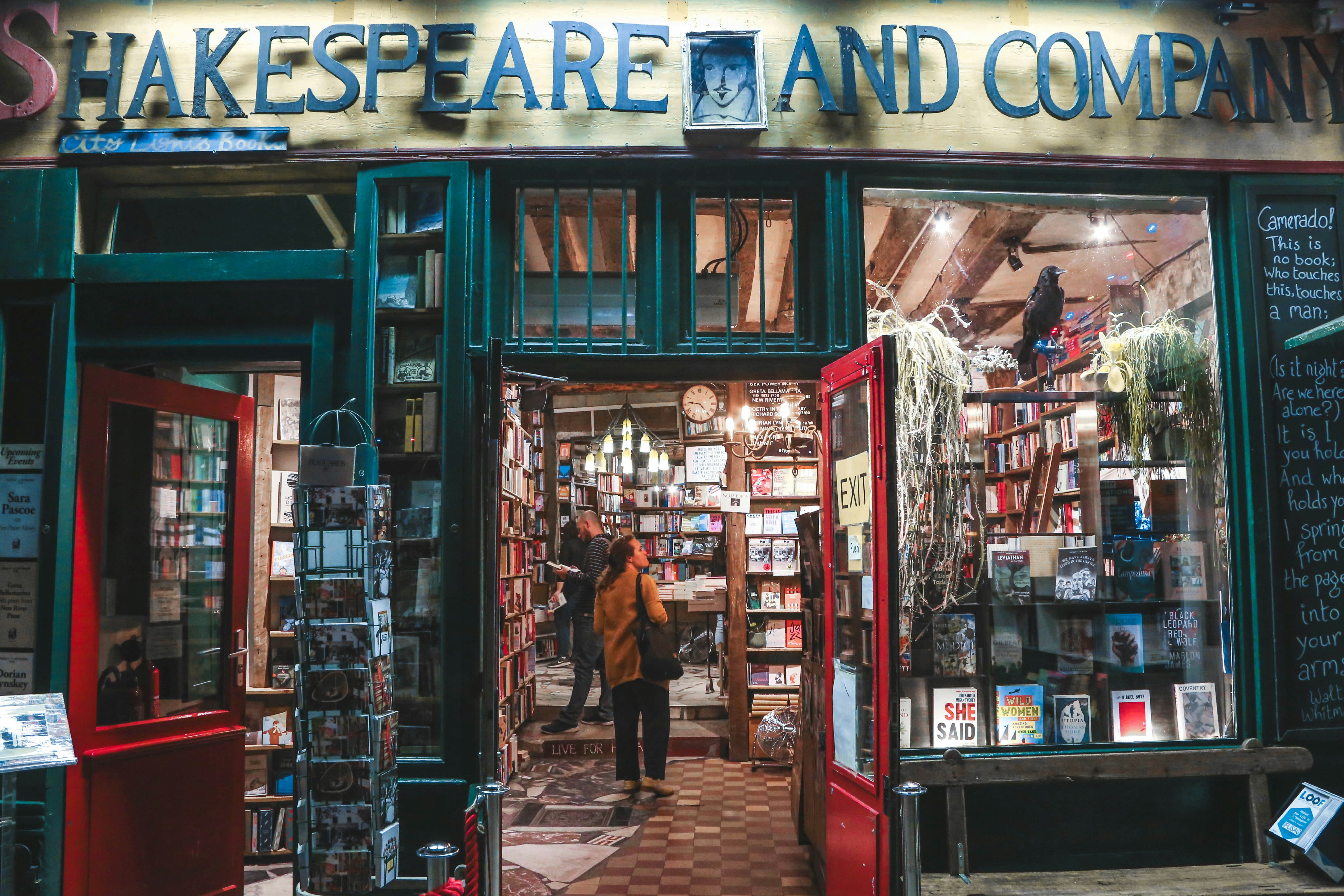 a man standing outside of a book store, Book store in Paris, France.