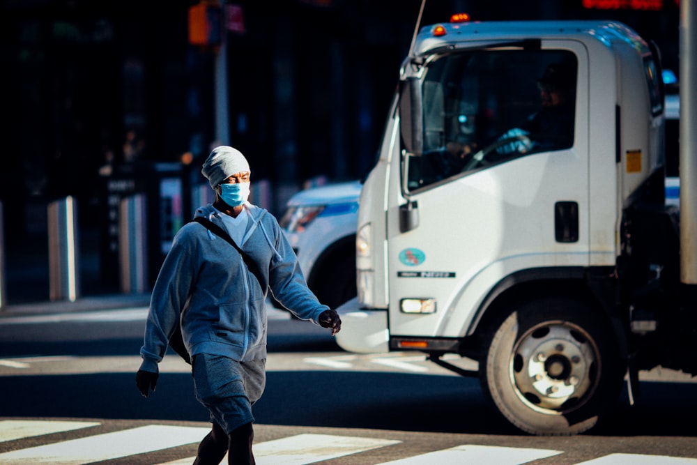 man in blue jacket walking on street during daytime