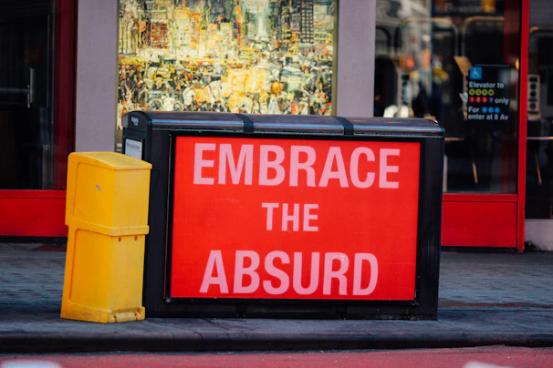 a red sign that says embrace the absurd